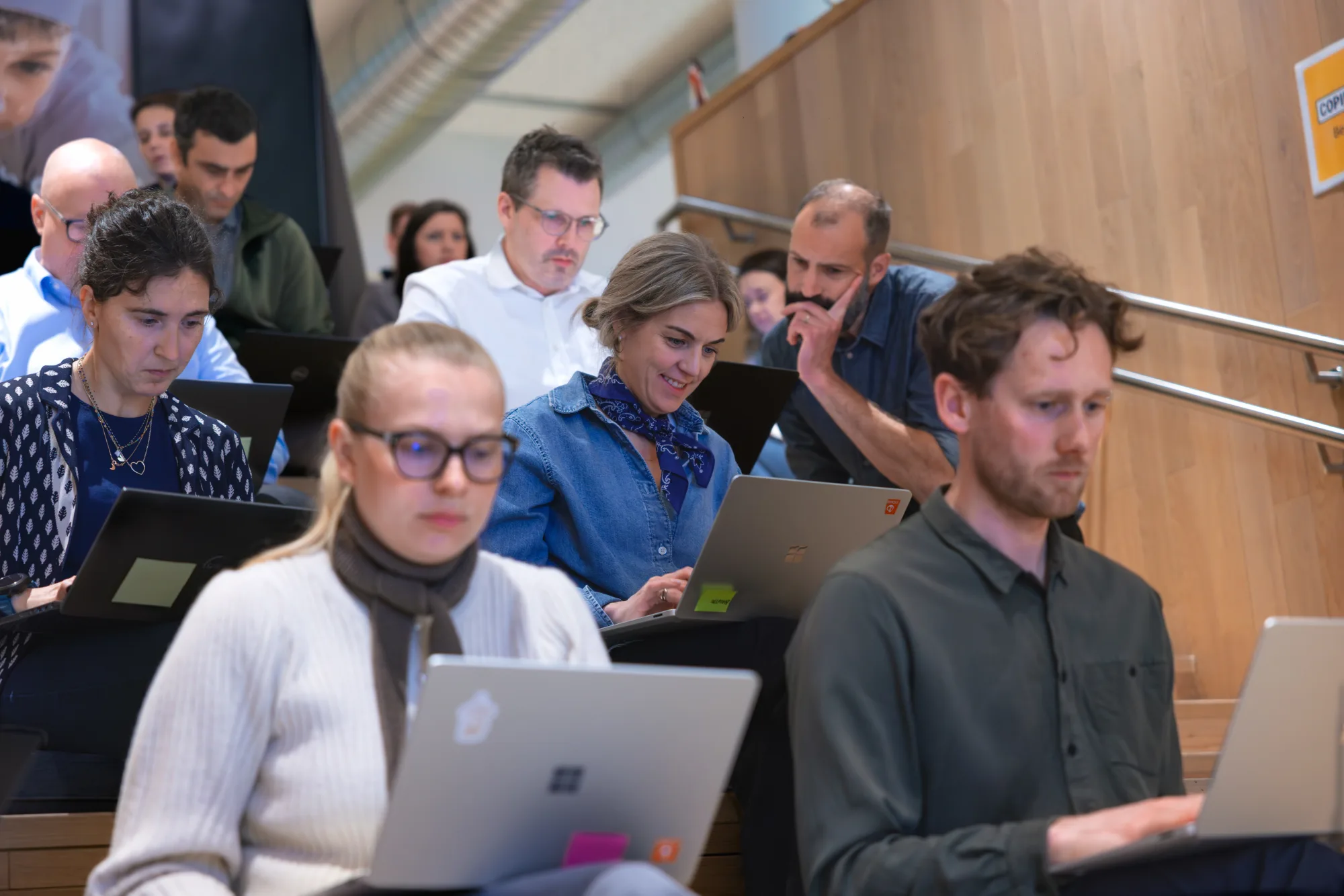 Focused participants working on laptops during an AI training session